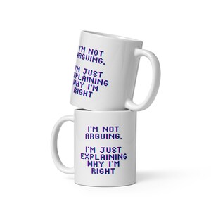 May include: Two white ceramic mugs stacked on top of each other. Each mug has the text "I'M NOT ARGUING. I'M JUST EXPLAINING WHY I'M RIGHT" in a pixelated blue font. The mugs have a curved handle.