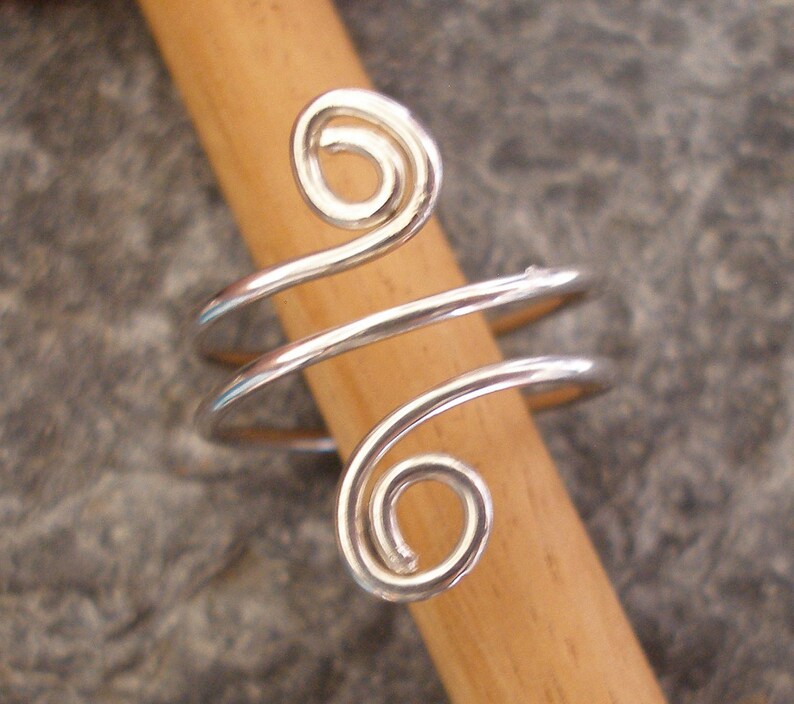 A sterling silver ring that threads round your finger 3 times, in a spiral.  The ends are curled into a loop.  The ring is highly polished.  The ring can be made in any size.