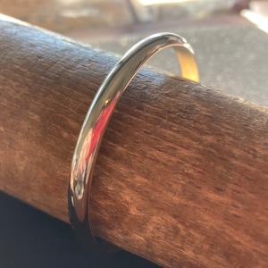 May include: A silver bangle bracelet with a smooth, polished finish.