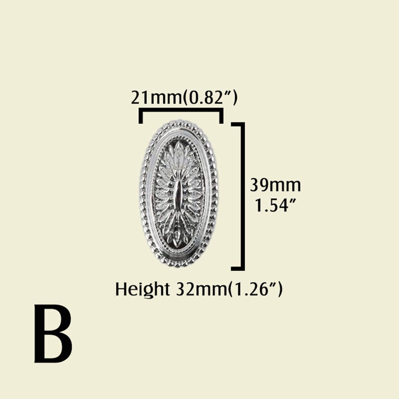 May include: A silver-colored, oval-shaped decorative furniture knob with a detailed floral design. The knob measures 0.82 inches wide, 1.54 inches long, and 1.26 inches in height. The letter "B" is at the bottom.