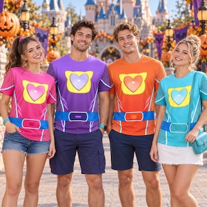 May include: Four short-sleeved t-shirts featuring a central heart emblem, a blue belt graphic at the waist, and a honeycomb pattern on the sleeves. The shirts are pink, purple, orange, and light blue, each with a matching heart and belt colour.