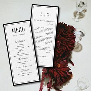 Peut inclure: Cartes de mariage élégantes, comprenant un menu et une carte de remerciement, avec des bordures noires. Le menu détaille le repas, tandis que la carte exprime la gratitude. Un arrangement floral rouge foncé et des verres en cristal complètent l'ensemble.