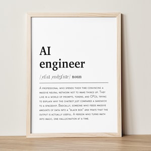 May include: A framed print with the definition of "AI engineer" in black text on a white background. The definition includes the phonetic pronunciation and a humorous description of the profession.