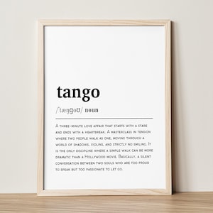 Puede incluir: Un marco de madera clara que contiene una impresión con la palabra "tango" en negro. Debajo, la pronunciación fonética y una definición del tango están impresas en negro sobre un fondo blanco. El marco es de color madera clara.