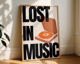 May include: A framed art print with the words "LOST IN MUSIC" in large black letters. An illustration of an orange record player is in the upper right corner. The print is in a wooden frame and leans against a white wall.