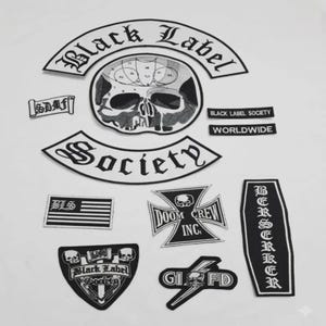 May include: A collection of black and white embroidered patches. The patches feature text such as "Black Label Society", "Society", and "Doom Crew Inc.". Several patches include skull imagery and a flag design.