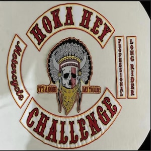 Puede incluir: Parches bordados de club de motociclistas con las palabras "HOKA HEY" y "CHALLENGE" en rojo y blanco. Un parche central presenta una calavera con un tocado nativo americano y una bandana amarilla. Parches adicionales dicen "Motorcycle", "Professional" y "Long Rider".