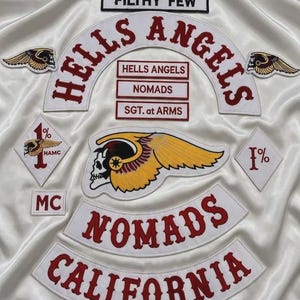 Może przedstawiać: Kolekcja haftowanych naszywek z napisami HELLS ANGELS, NOMADS, CALIFORNIA, FILTHY FEW, SGT. at ARMS oraz MC. Zestaw zawiera duży emblemat ze skrzydlatą czaszką, dwie mniejsze naszywki ze skrzydlatą czaszką oraz dwie naszywki w kształcie rombu 1%.
