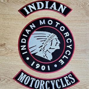 May include: Three embroidered patches with the words "INDIAN MOTORCYCLE" and "1901". The central patch is circular, featuring a Native American profile in white against a black background, encircled by the words "INDIAN MOTORCYCLE".