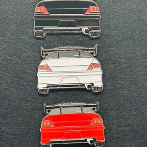 Puede incluir: Una taza de cerámica blanca con un asa negra y el texto "But First, Coffee" en negro, con una fuente de estilo manuscrito. La taza está sobre una superficie blanca.