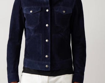 May include: A navy blue suede jacket with a classic design. The jacket features a button-up front, two chest pockets, and two lower pockets. A stylish outerwear piece.