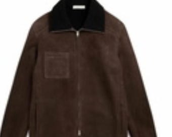 Könnte beinhalten: Braune Wildlederjacke mit schwarzem Kragen und Frontreißverschluss. Die Jacke hat eine einzelne quadratische Tasche auf der Brust und ein klassisches, maßgeschneidertes Design. Die Jacke ist mittelschwer.