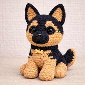 Puede incluir: Un cachorro de pastor alemán tejido a ganchillo, en colores negro y marrón claro. El peluche hecho a mano tiene ojos grandes y negros, una nariz negra y una etiqueta en forma de hueso en su collar. El cachorro está sentado erguido con la cola enroscada.