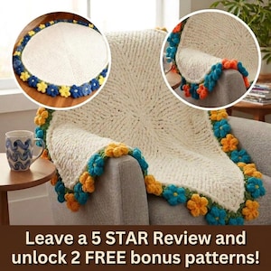 May include: Cream-colored, chunky knit blanket with a floral border in blue, yellow, and orange. The blanket is draped over a gray armchair. A mug with a blue wave pattern sits on a side table. The image also contains text.