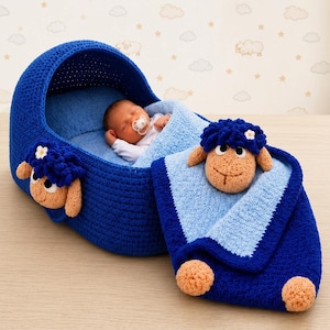 May include: A deep blue crocheted baby bassinet with a matching blanket. The bassinet and blanket feature tan sheep heads with dark blue curly wool and small white flowers. A baby with a pacifier rests inside the soft blue interior lining.