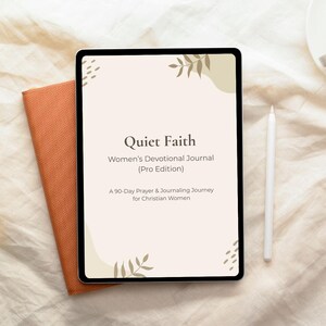 Könnte beinhalten: Ein digitales Tablet, das das Cover eines Andachtsbuchs mit dem Titel "Quiet Faith" anzeigt. Das Cover ist hellbeige mit Blättern und dem Text "Women's Devotional Journal (Pro Edition)". Ein orangefarbenes Journal und ein weißer Stift sind ebenfalls sichtbar.