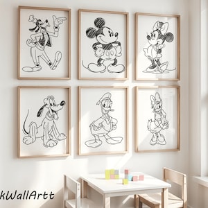 May include: Six framed black and white sketches of Disney characters, including Goofy, Mickey Mouse, Minnie Mouse, Pluto, Donald Duck, and Daisy Duck. The artwork is displayed on a white wall with a small white table and colorful blocks.