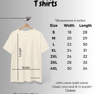 May include: Cream-colored t-shirt hanging on a hanger, with a size guide chart. The chart lists measurements in inches for width and length, ranging from size S to 4XL. The shirt is 100% cotton, classic crew-neck fit, and unisex.