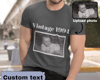 May include: Dark gray t-shirt with the text "Vintage 1994" above a black and white photo of a baby. The shirt also has a small photo of a baby and the words "Upload photo".