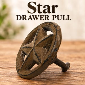 May include: A brown, textured, star-shaped drawer pull with a circular outer ring and a central five-pointed star. The metal hardware features a distressed finish and includes a threaded bolt extending from the back. Text reads: Star DRAWER PULL.