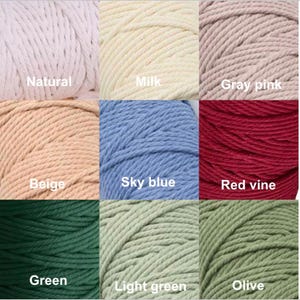 Puede incluir: Primer plano de nueve madejas de hilo de macram&eacute; en varios colores. Los colores incluyen natural, leche, rosa gris, beige, azul cielo, rojo vid, verde, verde claro y oliva. Cada madeja est&aacute; etiquetada con su nombre de color.