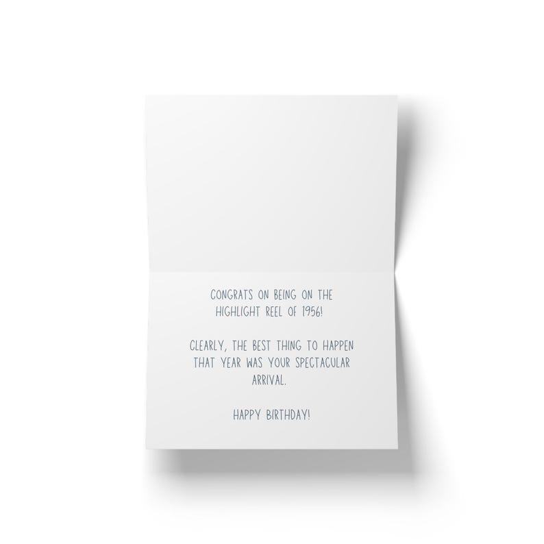 May include: A white greeting card with the text "CONGRATS ON BEING ON THE HIGHLIGHT REEL OF 1956! CLEARLY, THE BEST THING TO HAPPEN THAT YEAR WAS YOUR SPECTACULAR ARRIVAL. HAPPY BIRTHDAY!" in a blue font. The card is open, revealing the message.