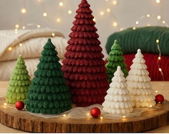 May include: A collection of decorative Christmas trees in various sizes and colors, including green, red, and white. The trees are arranged on a wooden base with small red ornaments and fairy lights, creating a festive holiday display.