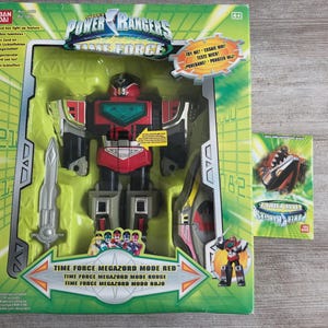 Könnte beinhalten: Eine Power Rangers Time Force Megazord Mode Red Actionfigur in der Box. Der Spielzeugroboter ist rot, schwarz und silberfarben, mit Schwert und Schild. Die Box ist grün und zeigt das Power Rangers Logo und Text in mehreren Sprachen.