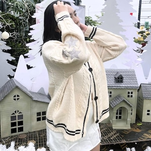 Retro-Stern-Zopfmuster-Strickjacke Folklore-inspirierter Pullover, Cremefarbe mit silbernem gesticktem Stern