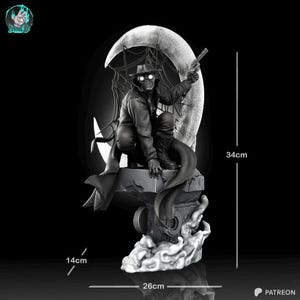 Pu&ograve; includere: Statua in bianco e nero di una figura con cappotto lungo e cappello, che tiene una pistola, accovacciata di fronte a una luna crescente con un disegno a ragnatela. La statua &egrave; alta 34 cm, larga 26 cm e profonda 14 cm.