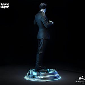 Puede incluir: Una estatua de Tony Stark de la serie Iron Man, vista desde atr&aacute;s. Lleva un traje de raya diplom&aacute;tica y est&aacute; de pie sobre una plataforma futurista con iluminaci&oacute;n azul. Las palabras "Ironman Tony Stark" est&aacute;n en la esquina superior izquierda.