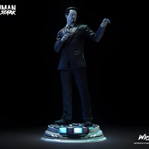Puede incluir: Estatua de Tony Stark con traje de raya diplom&aacute;tica negro, de pie sobre una plataforma futurista. La estatua tiene una expresi&oacute;n seria y sostiene un micr&oacute;fono. Las palabras "Ironman Tony Stark" est&aacute;n en la parte superior izquierda.