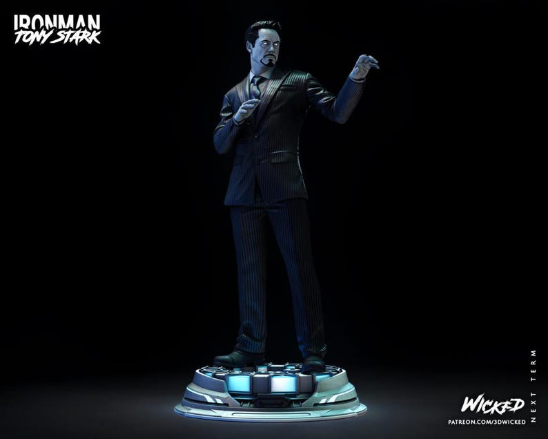 Puede incluir: Estatua de Tony Stark con traje de raya diplom&aacute;tica negro, de pie sobre una plataforma futurista. La estatua tiene una expresi&oacute;n seria y sostiene un micr&oacute;fono. Las palabras "Ironman Tony Stark" est&aacute;n en la parte superior izquierda.