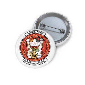 May include: White button featuring a cartoon Maneki Neko cat with a gold coin, set against a red and gold background. The text "MANEKI NEKO" and "GOOD FORTUNE & LUCK" are displayed on the button.