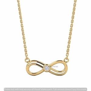 Può includere: Una collana in oro con un ciondolo a forma di simbolo dell'infinito, caratterizzato da una singola pietra preziosa rotonda e trasparente al centro. Il ciondolo è fissato a una sottile catenina d'oro con piccoli maglie rettangolari.