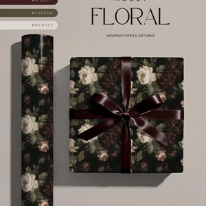 Puede incluir: Un rollo de papel de regalo y una caja cuadrada envuelta con el mismo papel, con un fondo negro y motivos florales en blanco, crema y rojo oscuro. La caja de regalo est&aacute; atada con una cinta de sat&eacute;n de color burdeos oscuro.