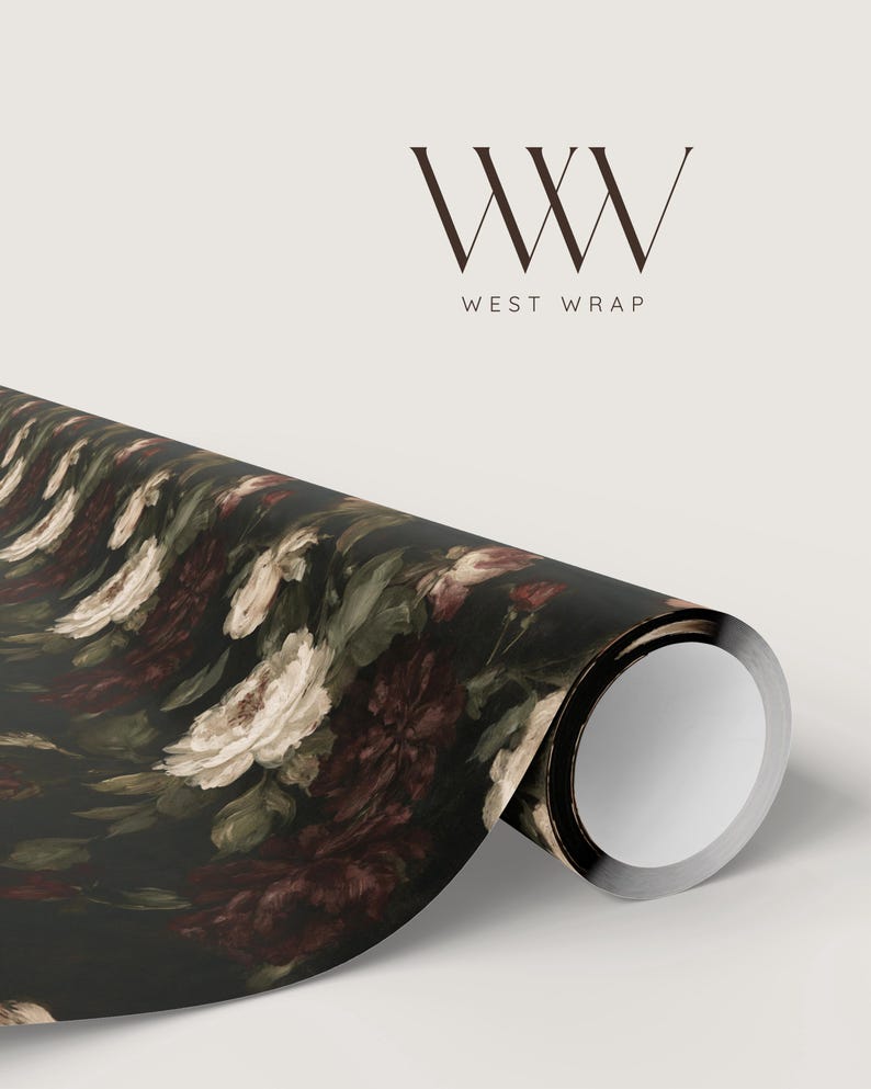 Puede incluir: Un rollo de papel de regalo con fondo negro y un estampado floral de rosas blancas y burdeos oscuro con hojas verdes. El logotipo WW WEST WRAP est&aacute; impreso en color marr&oacute;n oscuro sobre el rollo, en un fondo de color neutro claro.