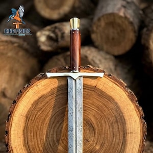 Op de afbeelding: Een recht zwaard met een patroon van Damascusstaal, een pareerstang en een donkerbruin houten handvat met een koperen pommel. Het lemmet vertoont een duidelijke golvende, gemarmerde metaalstructuur. Het logo King Fisher Knives is zichtbaar.