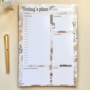 Peut inclure: Un bloc-notes blanc avec le texte "Today's plan". Le bloc-notes comprend des sections pour la planification, les rappels, les listes de tâches, les objectifs et les notes, avec des éléments de design floraux et abstraits en marron et beige.