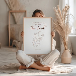 Peut inclure: Une affiche encadrée avec le texte "Ma famille et moi, nous servirons le Seigneur" et une illustration au trait de deux visages. L'affiche est tenue par une personne assise en tailleur sur un tapis. Le fond comprend des éléments décoratifs.