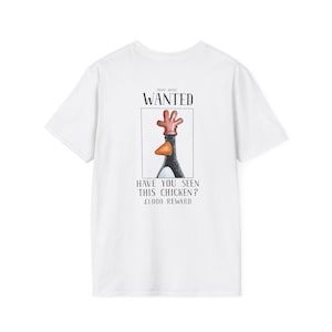 Puede incluir: Camiseta blanca con una ilustración de un pollo de dibujos animados, enmarcada como un póster de "SE BUSCA". El texto dice "¿HA VISTO ESTE POLLO?" y "£1000 RECOMPENSA". El pollo tiene una cresta roja y un pico naranja.