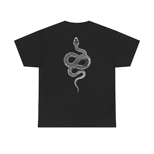 Peut inclure: T-shirt noir avec une illustration détaillée en niveaux de gris d'un serpent enroulé verticalement. Le motif du serpent est centré sur le devant du t-shirt, offrant un fort contraste avec le tissu sombre. Le design est détaillé et complexe.