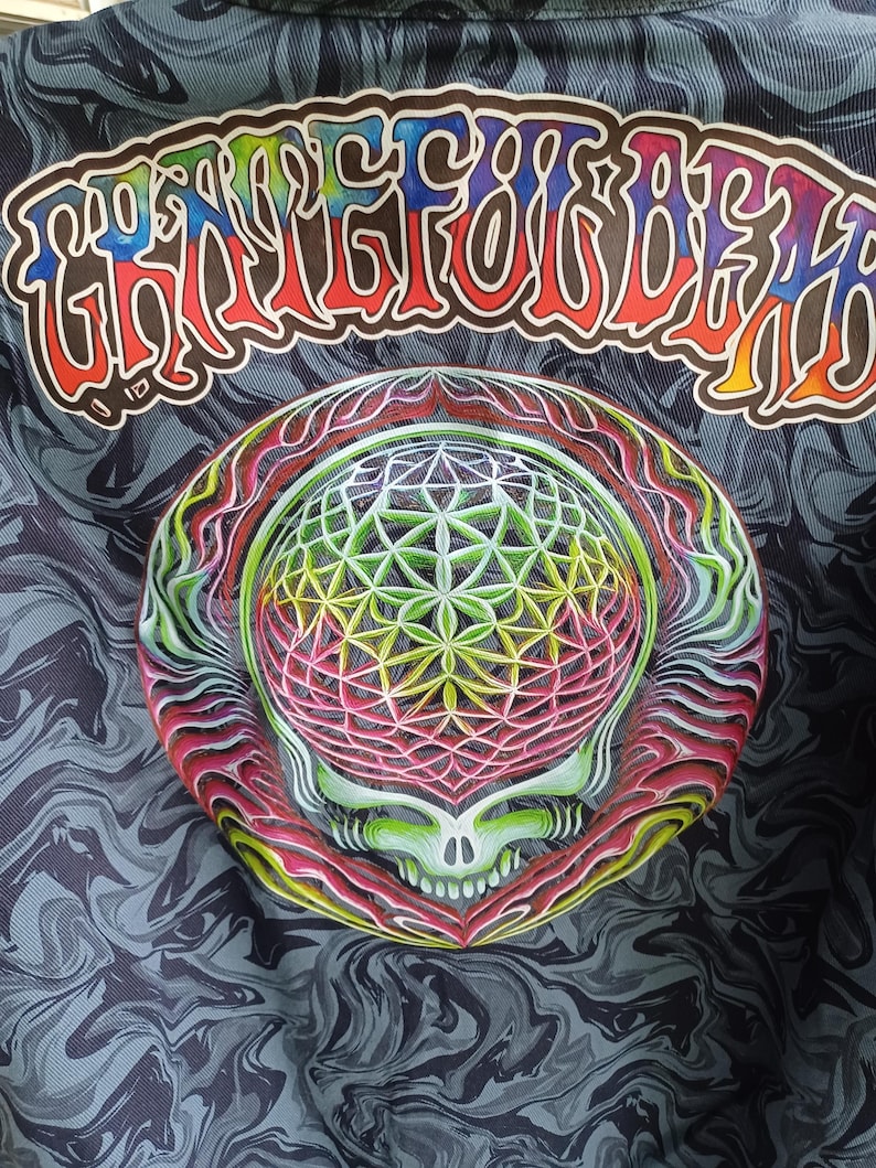 May include: A dark gray fabric with a swirling pattern, featuring a colorful graphic of a skull with a geometric design and the text "Grateful Dead" in a rainbow font.