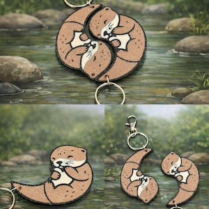 Könnte beinhalten: Braune Otter-Schlüsselanhänger mit schwarzem Rand und silberfarbener Hardware. Die Schlüsselanhänger zeigen ein Otter-Design mit weißem Bauch und Gesicht. Die Schlüsselanhänger werden in verschiedenen Anordnungen gezeigt.