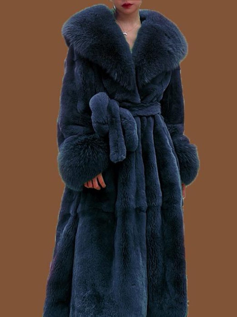 May include: A long, navy blue faux fur coat with a large collar and cuffs. The coat features a matching belt and is designed to be floor-length. The plush texture and deep colour create a luxurious look. The coat's measurements are approximately 152 cm in length.