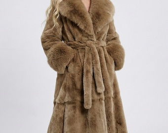 May include: A long, brown faux fur coat with a wide collar, long sleeves, and a matching belt. The coat has a tiered design and is knee-length, offering a luxurious and warm aesthetic. The coat is designed for cold weather.