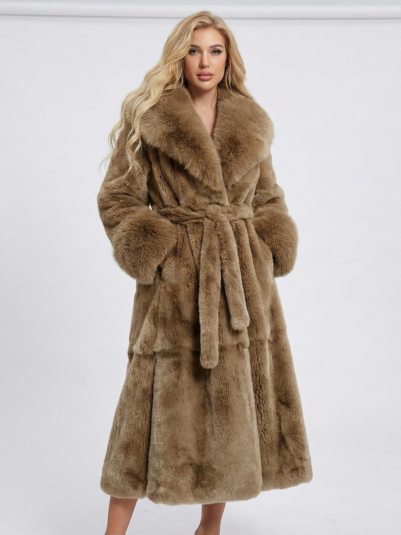 May include: A long, brown faux fur coat featuring a wide collar, long sleeves, and a matching belt. The coat has a tiered design and is knee-length, offering a luxurious and warm aesthetic. The coat is designed for cold weather.