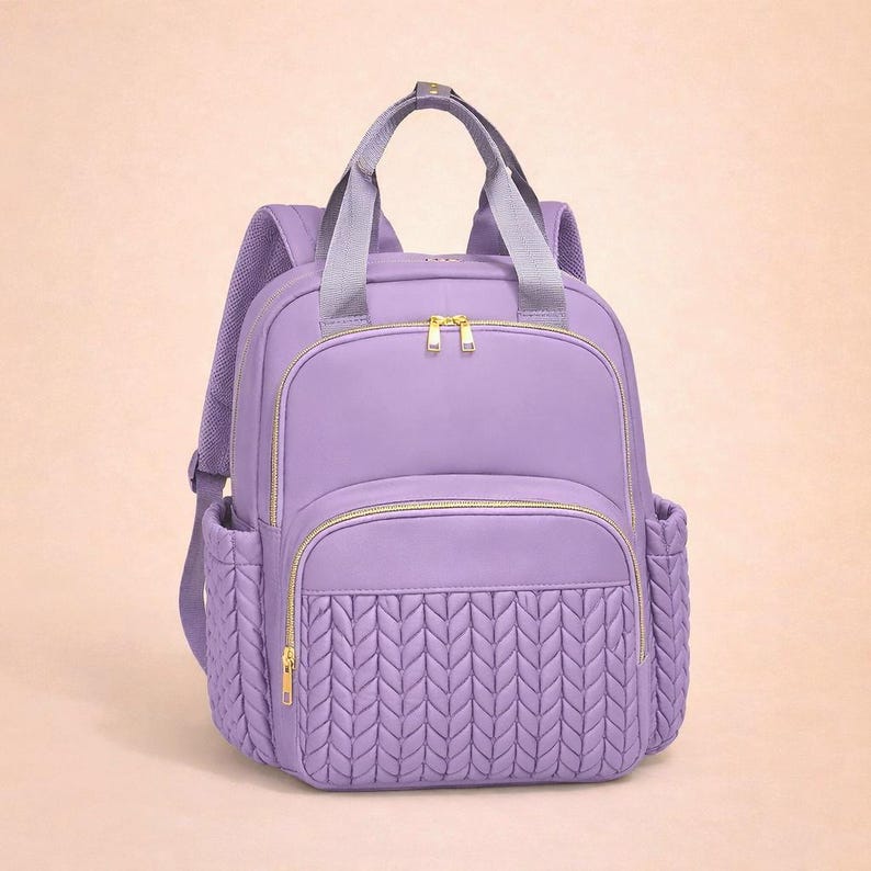 purple diaper backpack on beige background, stylish baby diaper bag