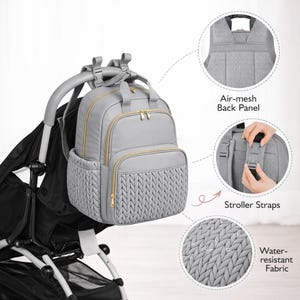 Gray diaper backpack attached to stroller showing storage pockets and water resistant fabric