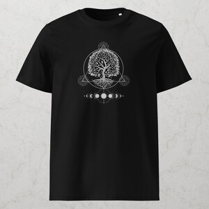 May include: Black t-shirt featuring a white graphic of a tree with roots, a circular design, geometric shapes, and phases of the moon. The design is centered on the front of the shirt, creating a striking visual.